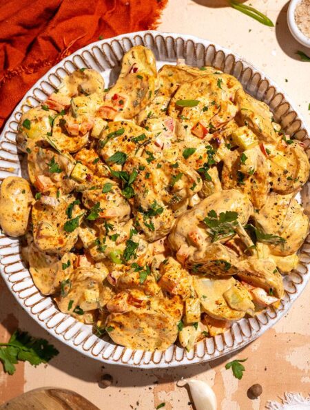 Cajun potato salad recipe with roasted potatoes, creamy dressing and fresh herbs.