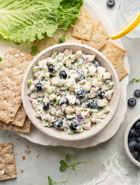 Overhead view of a bowl of Blueberry Chicken Salad surrounded by crackers.