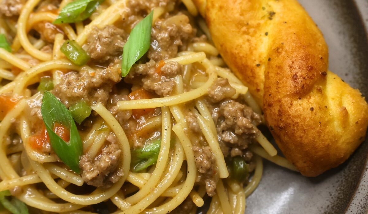 A serving of dirty spaghetti on a plate with garlic bread