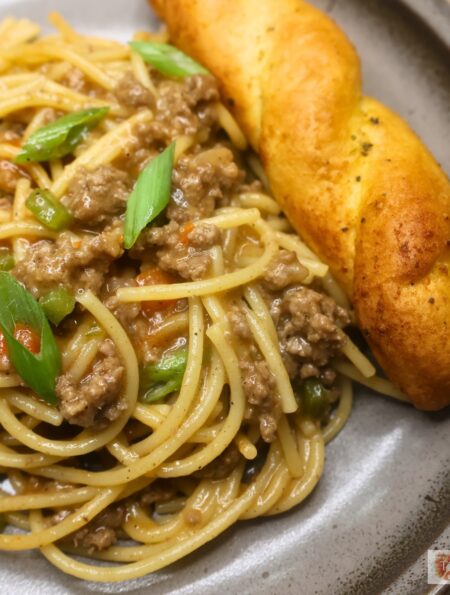 A serving of dirty spaghetti on a plate with garlic bread
