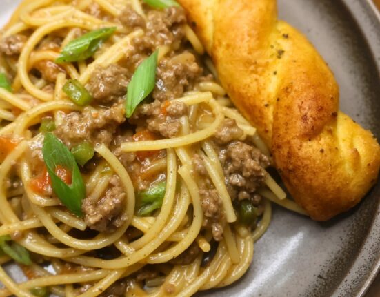 A serving of dirty spaghetti on a plate with garlic bread