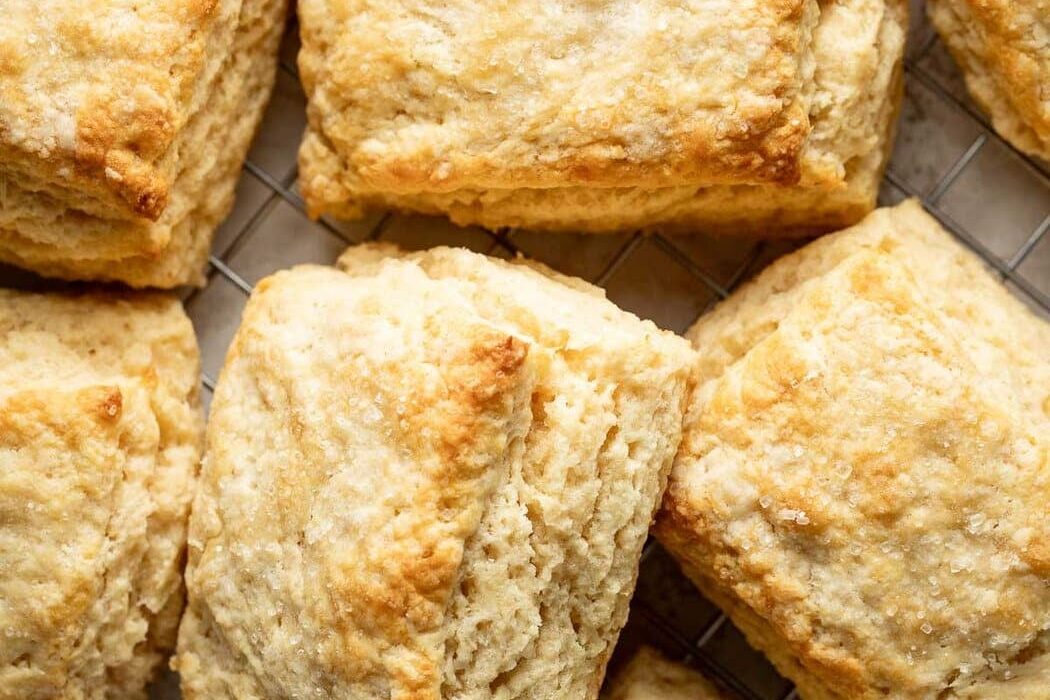 Close up view of sweet cream biscuits on a wire cooling rack showing the flakey layers