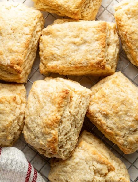 Close up view of sweet cream biscuits on a wire cooling rack showing the flakey layers