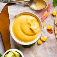 A small ramekin of vegan nacho cheese sauce.