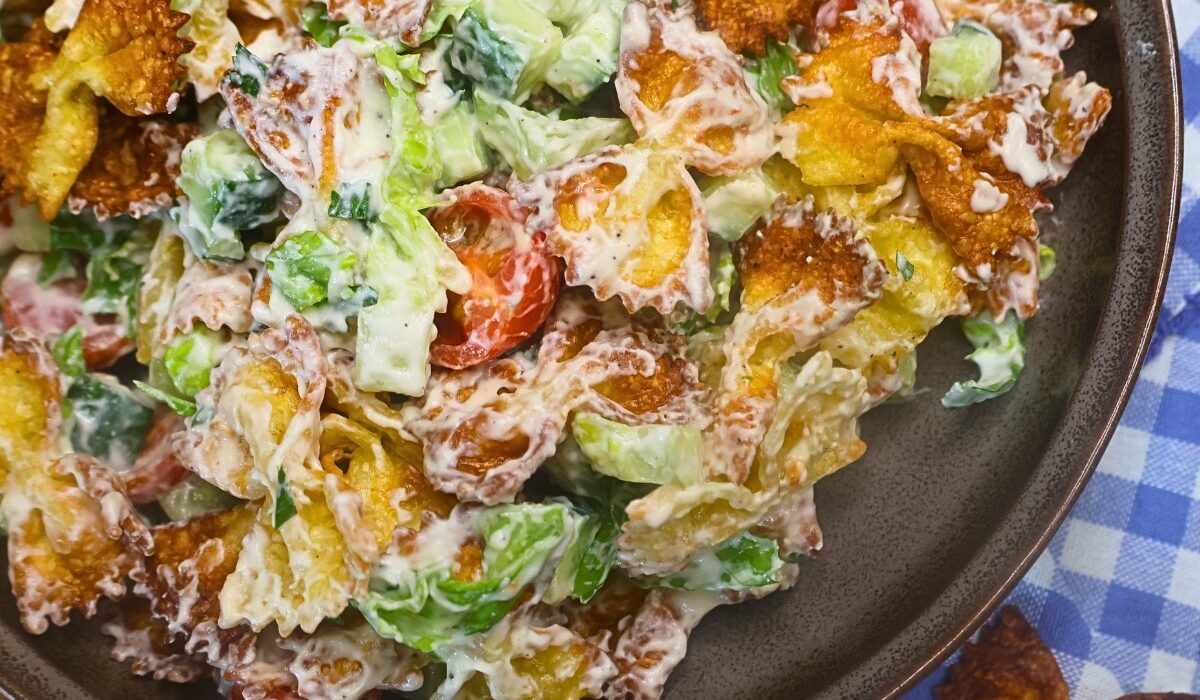 Overhead image of Crispy Pasta salad in a bowl with blue gingham cloth in the background