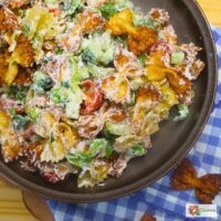 Overhead image of Crispy Pasta salad in a bowl with blue gingham cloth in the background