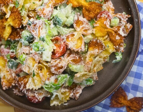 Overhead image of Crispy Pasta salad in a bowl with blue gingham cloth in the background